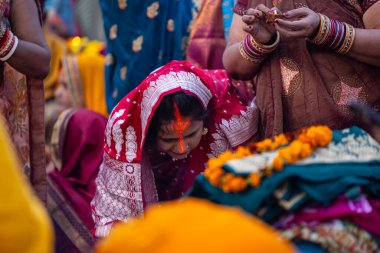 Gaziabad, Uttar Pradesh, Hindistan - 19 Kasım 2023: Chhas Puja, bir grup Hintli kadın geleneksel etnik kıyafetlerle Chhas puja ayinlerini gerçekleştirmek için yerlerinde oturuyorlar.