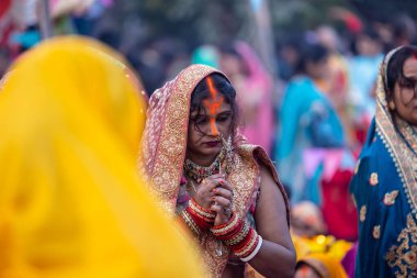 Gaziabad, Uttar Pradesh, Hindistan - 19 Kasım 2023: Chhas Puja, bir grup Hintli kadın geleneksel etnik kıyafetlerle chhas puja ayinlerini gerçekleştirmek için ayaktalar.