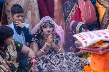 Gaziabad, Uttar Pradesh, Hindistan - 19 Kasım 2023: Chhas Puja, bir grup Hintli kadın geleneksel etnik kıyafetlerle Chhas puja ayinlerini gerçekleştirmek için yerlerinde oturuyorlar.