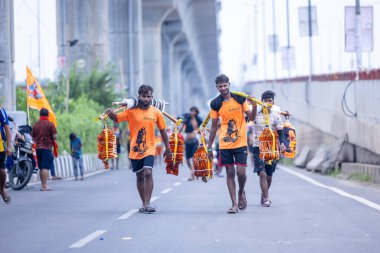 Gaziabad, Uttar Pradesh, Hindistan - 31 Temmuz 2024: Sawan Shivratri sırasında çıplak ayakla Kanwar Yatra 'yı seslendiren Hindu hacıların portresi ve Hindu tanrısı Shiva' ya ibadet etmek için kutsal Ganga suyu taşımak.