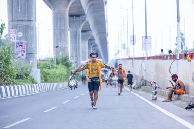 Gaziabad, Uttar Pradesh, Hindistan - 31 Temmuz 2024: Sawan Shivratri sırasında çıplak ayakla Kanwar Yatra 'yı seslendiren Hindu hacıların portresi ve Hindu tanrısı Shiva' ya ibadet etmek için kutsal Ganga suyu taşımak.