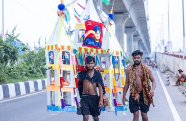 Gaziabad, Uttar Pradesh, Hindistan - 31 Temmuz 2024: Sawan Shivratri sırasında çıplak ayakla Kanwar Yatra 'yı seslendiren Hindu hacıların portresi ve Hindu tanrısı Shiva' ya ibadet etmek için kutsal Ganga suyu taşımak.