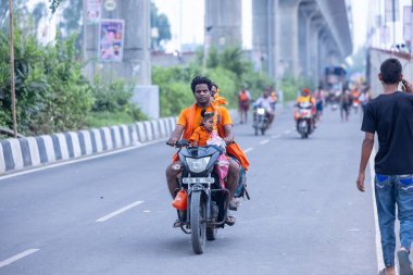 Gaziabad, Uttar Pradesh, Hindistan - 31 Temmuz 2024: Hindu hacıların Sawan Shivratri sırasında Kanwar Yatra 'yı icra eden ve Hindu tanrısı Shiva' ya ibadet etmek için kutsal Ganga suyu taşıyan portresi.