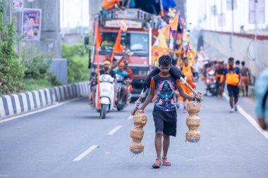 Gaziabad, Uttar Pradesh, Hindistan - 31 Temmuz 2024: Sawan Shivratri sırasında çıplak ayakla Kanwar Yatra 'yı seslendiren Hindu hacı portresi ve Hindu tanrısı Shiva' ya ibadet etmek için kutsal Ganga suyu taşımak.