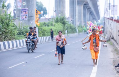 Gaziabad, Uttar Pradesh, Hindistan - 31 Temmuz 2024: Sawan Shivratri sırasında çıplak ayakla Kanwar Yatra 'yı seslendiren Hindu hacıların portresi ve Hindu tanrısı Shiva' ya ibadet etmek için kutsal Ganga suyu taşımak.