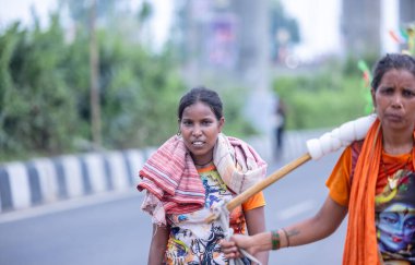 Gaziabad, Uttar Pradesh, Hindistan - 31 Temmuz 2024: Sawan Shivratri sırasında çıplak ayakla Kanwar Yatra 'yı seslendiren Hindu hacıların portresi ve Hindu tanrısı Shiva' ya ibadet etmek için kutsal Ganga suyu taşımak.