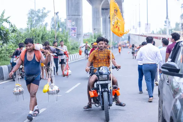 Gaziabad, Uttar Pradesh, Hindistan - 31 Temmuz 2024: Hindu hacıların Sawan Shivratri sırasında Kanwar Yatra 'yı icra eden ve Hindu tanrısı Shiva' ya ibadet etmek için kutsal Ganga suyu taşıyan portresi.