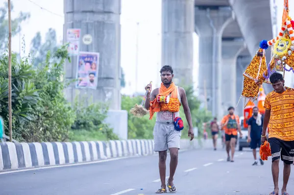 stock image Ghaziabad, Uttar Pradesh, India - July 31 2024: Portrait of Hindu pilgrims performing Kanwar Yatra barefoot during Sawan Shivratri and carrying holy ganga water to worship Hindu god Shiva with rituals.