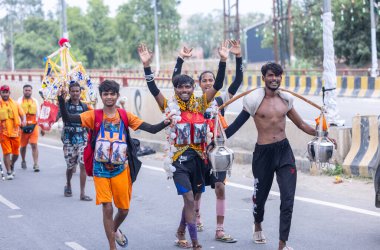 Gaziabad, Uttar Pradesh, Hindistan - 31 Temmuz 2024: Sawan Shivratri sırasında çıplak ayakla Kanwar Yatra 'yı seslendiren Hindu hacıların portresi ve Hindu tanrısı Shiva' ya ibadet etmek için kutsal Ganga suyu taşımak.