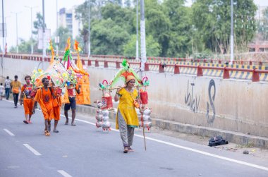 Gaziabad, Uttar Pradesh, Hindistan - 31 Temmuz 2024: Sawan Shivratri sırasında çıplak ayakla Kanwar Yatra 'yı seslendiren Hindu hacıların portresi ve Hindu tanrısı Shiva' ya ibadet etmek için kutsal Ganga suyu taşımak.