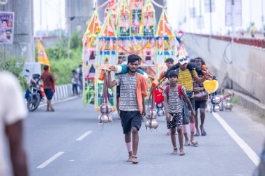 Gaziabad, Uttar Pradesh, Hindistan - 31 Temmuz 2024: Sawan Shivratri sırasında çıplak ayakla Kanwar Yatra 'yı seslendiren Hindu hacıların portresi ve Hindu tanrısı Shiva' ya ibadet etmek için kutsal Ganga suyu taşımak.