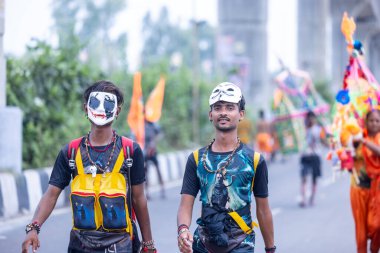 Gaziabad, Uttar Pradesh, Hindistan - 31 Temmuz 2024: Sawan Shivratri sırasında çıplak ayakla Kanwar Yatra 'yı seslendiren Hindu hacıların portresi ve Hindu tanrısı Shiva' ya ibadet etmek için kutsal Ganga suyu taşımak.