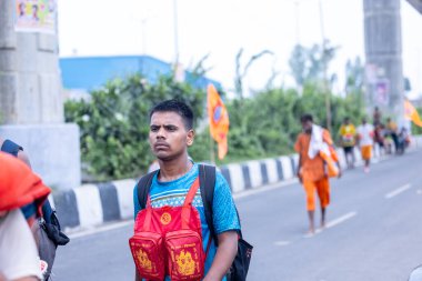 Gaziabad, Uttar Pradesh, Hindistan - 31 Temmuz 2024: Sawan Shivratri sırasında çıplak ayakla Kanwar Yatra 'yı seslendiren Hindu hacıların portresi ve Hindu tanrısı Shiva' ya ibadet etmek için kutsal Ganga suyu taşımak.