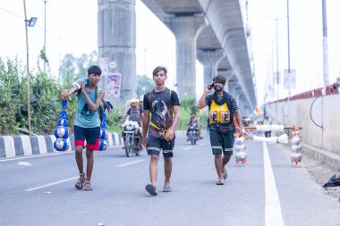 Gaziabad, Uttar Pradesh, Hindistan - 31 Temmuz 2024: Sawan Shivratri sırasında çıplak ayakla Kanwar Yatra 'yı seslendiren Hindu hacıların portresi ve Hindu tanrısı Shiva' ya ibadet etmek için kutsal Ganga suyu taşımak.