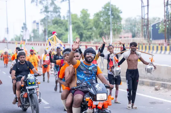 Gaziabad, Uttar Pradesh, Hindistan - 31 Temmuz 2024: Hindu hacıların Sawan Shivratri sırasında yürüyerek Kanwar Yatra 'yı sahneleyen ve Hindu tanrısı Shiva' ya ibadet etmek için kutsal Ganga suyu taşıyan portresi.