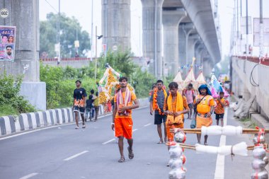 Gaziabad, Uttar Pradesh, Hindistan - 31 Ağustos 2024: Sawan shivratri sırasında çıplak ayakla Kanwar yatra yapan Hindu hacıların portresi.