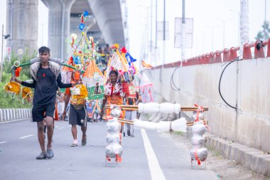 Gaziabad, Uttar Pradesh, Hindistan - 31 Ağustos 2024: Sawan shivratri sırasında çıplak ayakla Kanwar yatra yapan Hindu hacıların portresi.