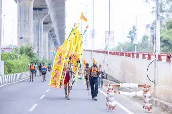 Gaziabad, Uttar Pradesh, Hindistan - 31 Ağustos 2024: Sawan shivratri sırasında çıplak ayakla Kanwar yatra yapan Hindu hacıların portresi.