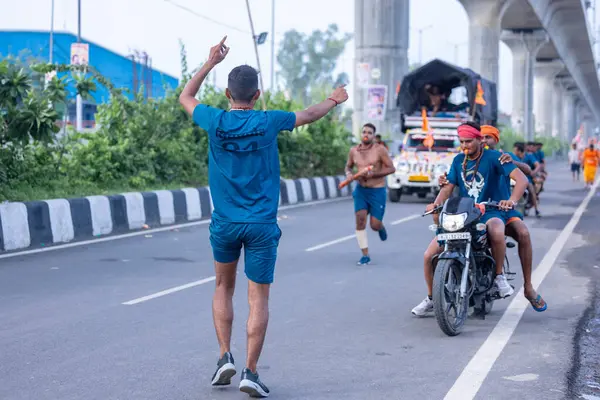 Gaziabad, Uttar Pradesh, Hindistan - 31 Ağustos 2024: Sawan shivratri sırasında çıplak ayakla Kanwar yatra yapan Hindu hacıların portresi.