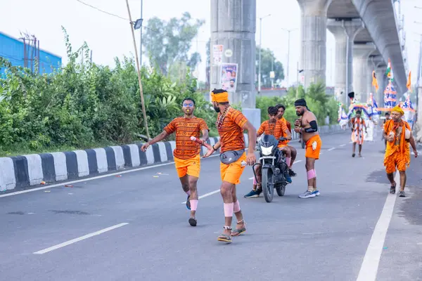 Gaziabad, Uttar Pradesh, Hindistan - 31 Ağustos 2024: Sawan shivratri sırasında çıplak ayakla Kanwar yatra yapan Hindu hacıların portresi.