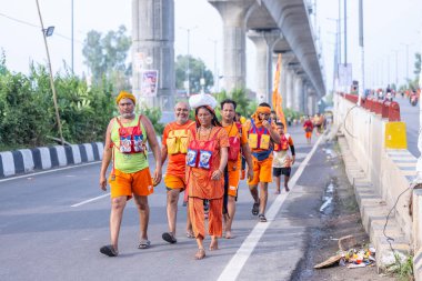 Gaziabad, Uttar Pradesh, Hindistan - 31 Ağustos 2024: Sawan shivratri sırasında çıplak ayakla Kanwar yatra yapan Hindu hacıların portresi.