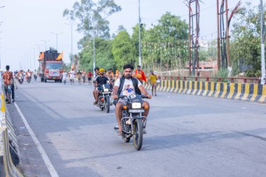 Gaziabad, Uttar Pradesh, Hindistan - 1 Ağustos 2024: Bir grup Hindu hacı Sawan shivratri sırasında Kanwar yatra 'yı sahnelerken ve Tanrı' ya ibadet etmek için kutsal kenevir suyu taşırken.