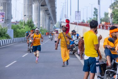 Gaziabad, Uttar Pradesh, Hindistan - 31 Ağustos 2024: Sawan shivratri sırasında çıplak ayakla Kanwar yatra yapan Hindu hacıların portresi.