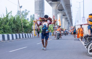 Gaziabad, Uttar Pradesh, Hindistan - 31 Ağustos 2024: Sawan shivratri sırasında çıplak ayakla Kanwar yatra yapan Hindu hacıların portresi.
