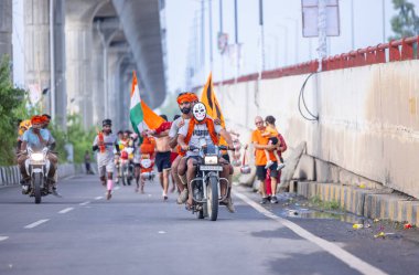 Gaziabad, Uttar Pradesh, Hindistan - 1 Ağustos 2024: Bir grup Hindu hacı Sawan shivratri sırasında Kanwar yatra 'yı sahnelerken ve Tanrı' ya ibadet etmek için kutsal kenevir suyu taşırken.