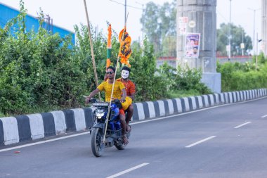 Gaziabad, Uttar Pradesh, Hindistan - 1 Ağustos 2024: Bir grup Hindu hacı Sawan shivratri sırasında Kanwar yatra 'yı sahnelerken ve Tanrı' ya ibadet etmek için kutsal kenevir suyu taşırken.