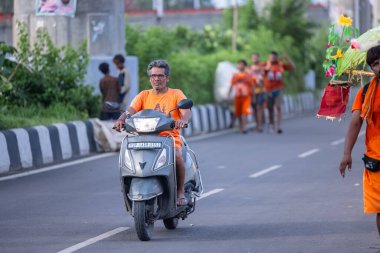 Gaziabad, Uttar Pradesh, Hindistan - 1 Ağustos 2024: Bir grup Hindu hacı Sawan shivratri sırasında Kanwar yatra 'yı sahnelerken ve Tanrı' ya ibadet etmek için kutsal kenevir suyu taşırken.