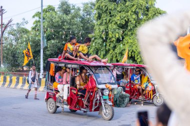 Gaziabad, Uttar Pradesh, Hindistan - 1 Ağustos 2024: Bir grup Hindu hacı Sawan shivratri sırasında Kanwar yatra 'yı sahnelerken ve Tanrı' ya ibadet etmek için kutsal kenevir suyu taşırken.