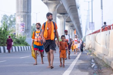 Gaziabad, Uttar Pradesh, Hindistan - 31 Ağustos 2024: Sawan shivratri sırasında çıplak ayakla Kanwar yatra yapan Hindu hacıların portresi.