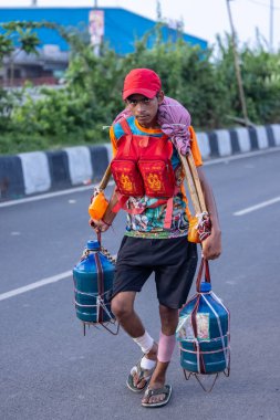 Gaziabad, Uttar Pradesh, Hindistan - 31 Ağustos 2024: Sawan shivratri sırasında çıplak ayakla kanwar yatra yapan Hindu hacı portresi ve Hindu tanrılarına ibadet etmek için kutsal kenevir suyu taşımak