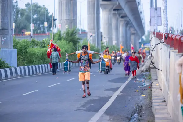 Gaziabad, Uttar Pradesh, Hindistan - 31 Ağustos 2024: Sawan shivratri sırasında çıplak ayakla Kanwar yatra yapan Hindu hacıların portresi.