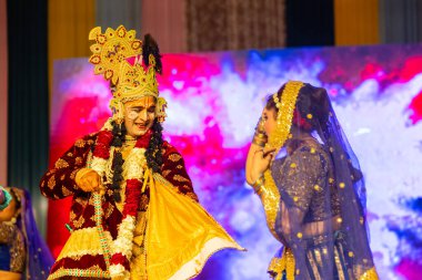 Gaziabad, Uttar Pradesh, Hindistan - 17 Mart 2024: Holi Festivali sırasında renkli etnik giysiler içinde sahnede phoolo ki holi 'yi oynayan genç bir sanatçının portresi.