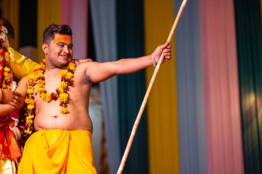 Gaziabad, Uttar Pradesh, Hindistan - 17 Mart 2024: Holi Festivali sırasında renkli etnik giysiler içinde sahnede phoolo ki holi 'yi oynayan genç bir sanatçının portresi.