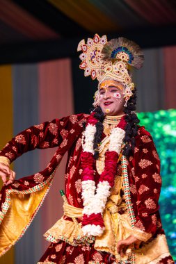 Gaziabad, Uttar Pradesh, Hindistan - 17 Mart 2024: Holi Festivali sırasında renkli etnik giysiler içinde sahnede phoolo ki holi 'yi oynayan genç bir sanatçının portresi.