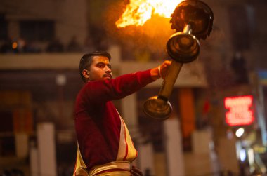 Varanasi, Uttar Pradesh, Hindistan - 18 Ocak 2024: Ganga aarti, Genç erkek rahibin portresi Dashashwamedh ghat 'ta kutsal nehir ganges akşam aarti gösterisi Hindu ayinleri ile geleneksel elbise. 