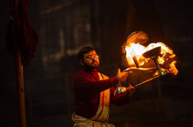 Varanasi, Uttar Pradesh, Hindistan - 18 Ocak 2024: Ganga aarti, Genç erkek rahibin portresi Dashashwamedh ghat 'ta kutsal nehir ganges akşam aarti gösterisi Hindu ayinleri ile geleneksel elbise. 