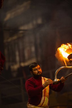 Varanasi, Uttar Pradesh, Hindistan - 18 Ocak 2024: Ganga aarti, Genç erkek rahibin portresi Dashashwamedh ghat 'ta kutsal nehir ganges akşam aarti gösterisi Hindu ayinleri ile geleneksel elbise. 