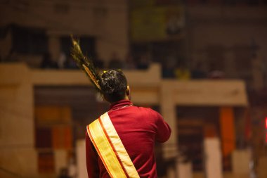 Varanasi, Uttar Pradesh, Hindistan - 18 Ocak 2024: Ganga aarti, Genç erkek rahibin portresi Dashashwamedh ghat 'ta kutsal nehir ganges akşam aarti gösterisi Hindu ayinleri ile geleneksel elbise. 