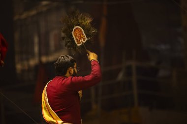 Varanasi, Uttar Pradesh, Hindistan - 18 Ocak 2024: Ganga aarti, Genç erkek rahibin portresi Dashashwamedh ghat 'ta kutsal nehir ganges akşam aarti gösterisi Hindu ayinleri ile geleneksel elbise. 