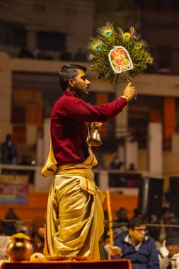 Varanasi, Uttar Pradesh, Hindistan - 18 Ocak 2024: Ganga aarti, Genç erkek rahibin portresi Dashashwamedh ghat 'ta kutsal nehir ganges akşam aarti gösterisi Hindu ayinleri ile geleneksel elbise. 