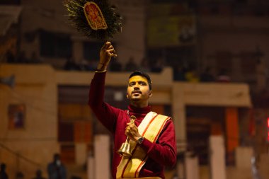 Varanasi, Uttar Pradesh, Hindistan - 18 Ocak 2024: Ganga aarti, Genç erkek rahibin portresi Dashashwamedh ghat 'ta kutsal nehir ganges akşam aarti gösterisi Hindu ayinleri ile geleneksel elbise. 
