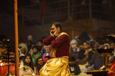 Varanasi, Uttar Pradesh, Hindistan - 18 Ocak 2024: Ganga aarti, Genç erkek rahibin portresi Dashashwamedh ghat 'ta kutsal nehir ganges akşam aarti gösterisi Hindu ayinleri ile geleneksel elbise. 