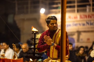 Varanasi, Uttar Pradesh, Hindistan - 18 Ocak 2024: Ganga aarti, Genç erkek rahibin portresi Dashashwamedh ghat 'ta kutsal nehir ganges akşam aarti gösterisi Hindu ayinleri ile geleneksel elbise. 