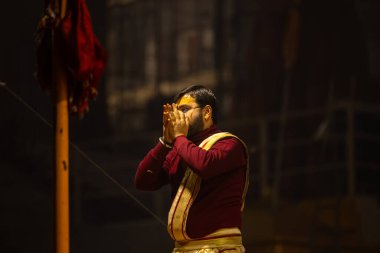 Varanasi, Uttar Pradesh, Hindistan - 18 Ocak 2024: Ganga aarti, Genç erkek rahibin portresi Dashashwamedh ghat 'ta kutsal nehir ganges akşam aarti gösterisi Hindu ayinleri ile geleneksel elbise. 