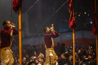 Varanasi, Uttar Pradesh, Hindistan - 18 Ocak 2024: Ganga aarti, Genç erkek rahibin portresi Dashashwamedh ghat 'ta kutsal nehir ganges akşam aarti gösterisi Hindu ayinleri ile geleneksel elbise. 