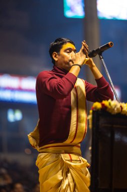 Varanasi, Uttar Pradesh, Hindistan - 18 Ocak 2024: Ganga aarti, Genç erkek rahibin portresi Dashashwamedh ghat 'ta kutsal nehir ganges akşam aarti gösterisi Hindu ayinleri ile geleneksel elbise. 